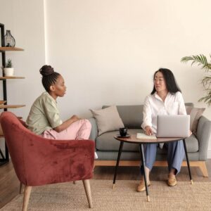 Shows a woman in trauma therapy in Fort Worth, TX and talking to her therapist in a chic office. Represents how a trauma therapist in Fort Worth, TX can help you address the unhealed trauma.